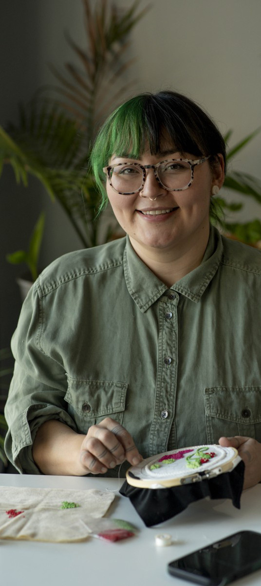 Un homme souriant, les bras croisés, penché à droite